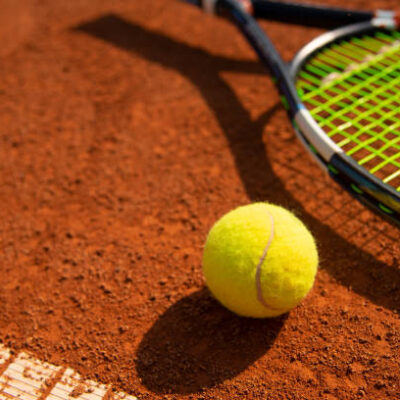 Tennis ball and racket on a tennis court in fine weather